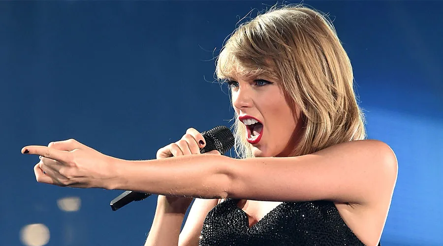 Η Taylor Swift τραγουδάει σε σκηνή κρατώντας μικρόφωνο