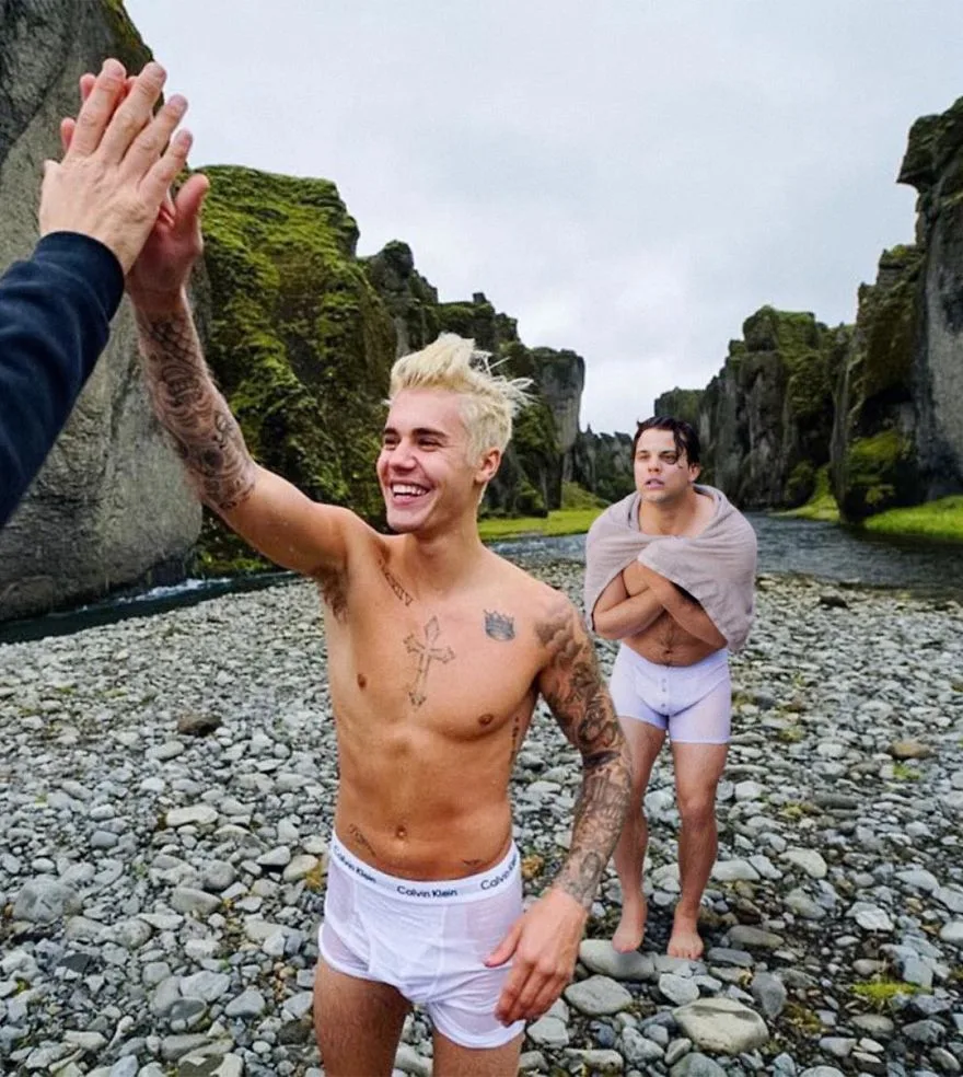Ο Justin Bieber και ο Average Bob σε βραχώδες τοπίο με ποτάμι.