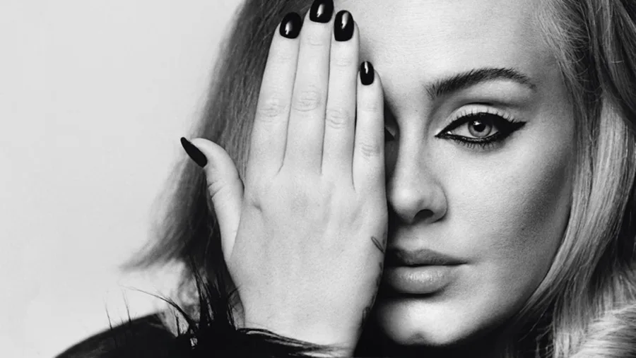 Ασπρόμαυρο κοντινό πορτρέτο της Adele με το χέρι να καλύπτει το ένα μάτι.