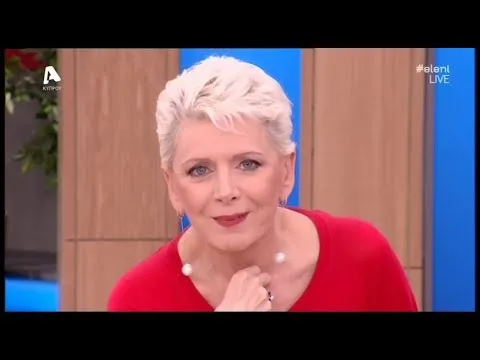 Ελληνίδα τραγουδίστρια με κοντό ξανθό μαλλί και κόκκινο ρούχο σε τηλεοπτικό πλατό.
