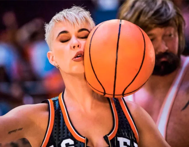 Η Katy Perry με μια μπάλα μπάσκετ να ακουμπά το πρόσωπό της.