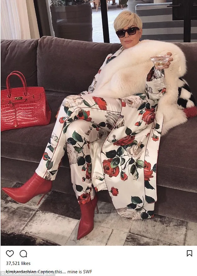 Η Kris Jenner με ξανθό πλατινέ μαλλί, λευκή γούνα και φλοράλ σύνολο σε καναπέ.