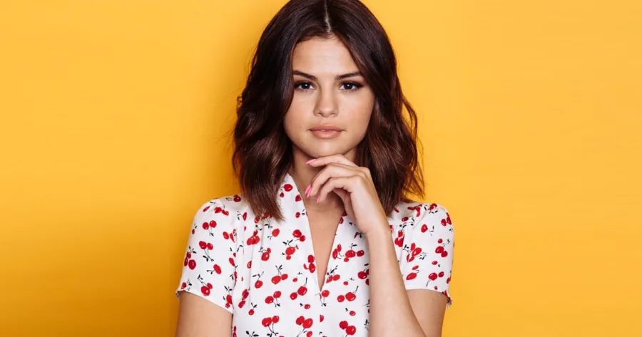 Η Selena Gomez ποζάρει σε κίτρινο φόντο.