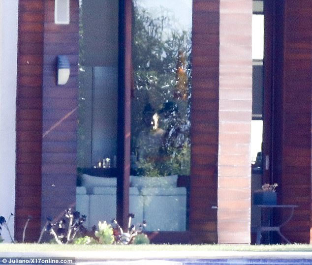 Ο Justin Bieber και η Selena Gomez μέσα από ένα παράθυρο σπιτιού.
