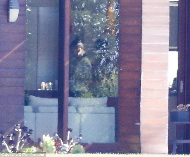 Ο Justin Bieber και η Selena Gomez μέσα από ένα παράθυρο σπιτιού.