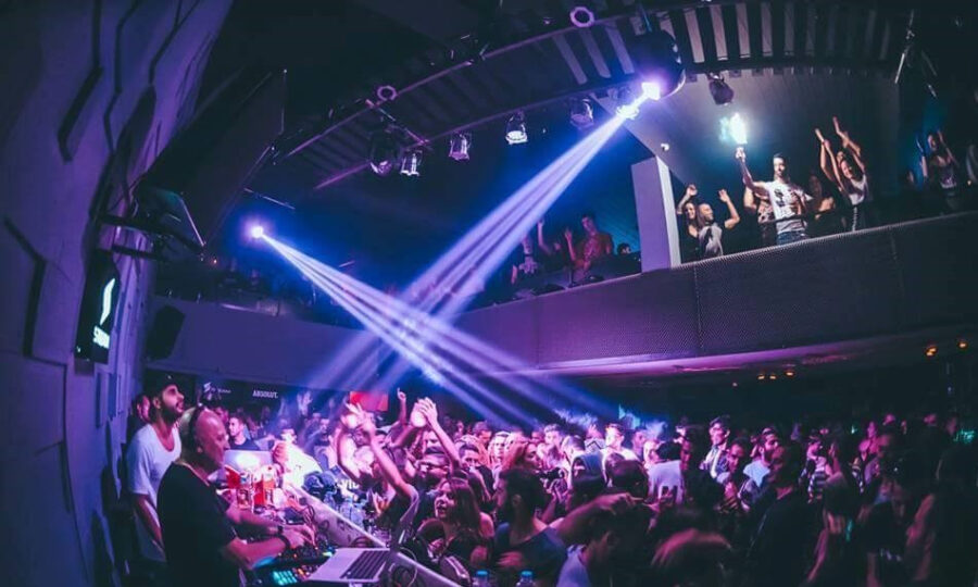 DJ παίζει μουσική σε γεμάτο club Steam με έντονα φώτα και πλήθος κόσμου.