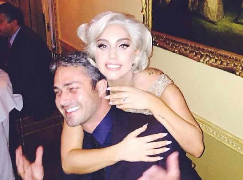 Η Lady Gaga αγκαλιάζει τον Taylor Kinney από πίσω.