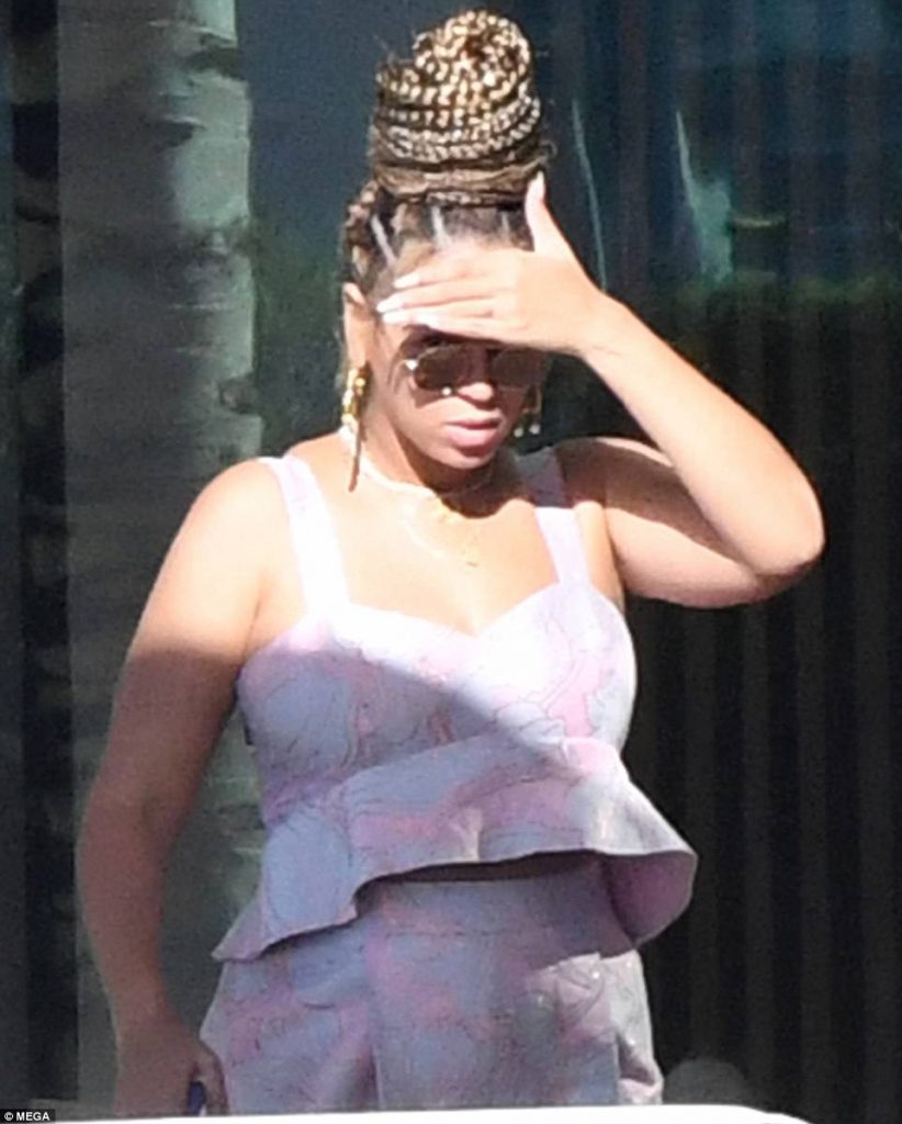 Η Beyoncé με πλεξούδες, γυαλιά ηλίου και ροζ σύνολο σε εξωτερικό χώρο.