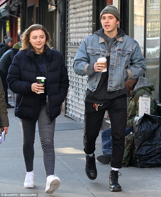 Ο Brooklyn Beckham και η Chloë Grace Moretz περπατούν στο δρόμο κρατώντας καφέ.