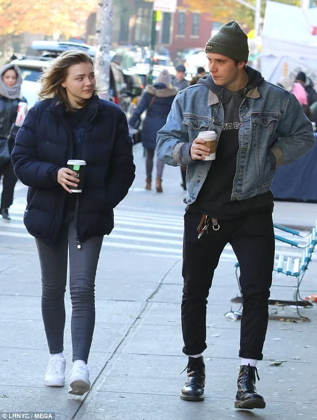 Ο Brooklyn Beckham και η Chloë Grace Moretz περπατούν στο δρόμο κρατώντας καφέ.