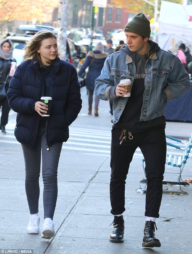 Ο Brooklyn Beckham και η Chloë Grace Moretz περπατούν στο δρόμο κρατώντας καφέ.