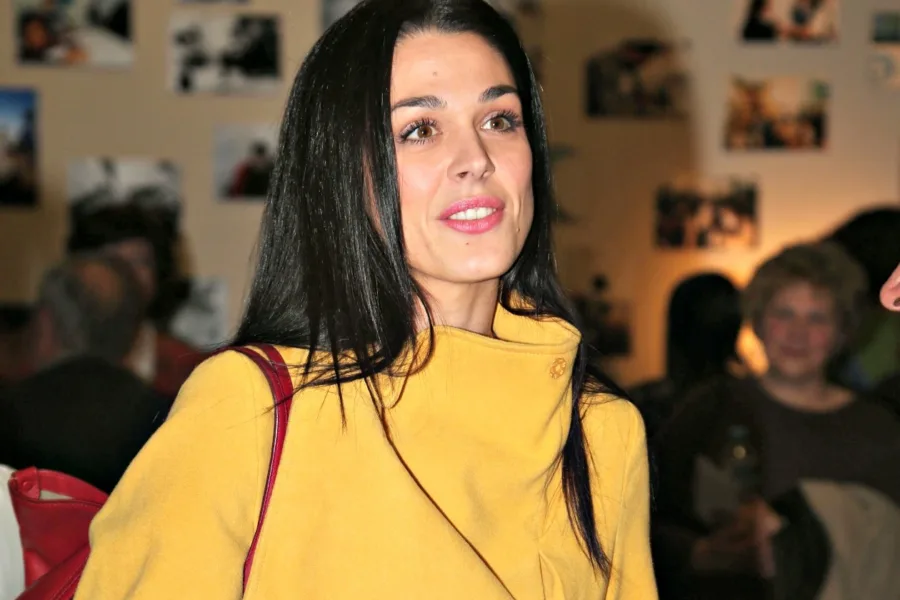 Η Ιωάννα Τριανταφυλλίδου με κίτρινο παλτό σε εκδήλωση.