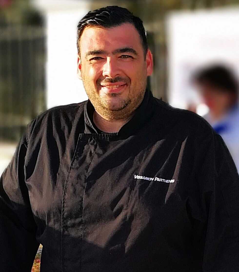 Ο Βησσαρίων Παρθένης με μαύρη στολή σεφ.
