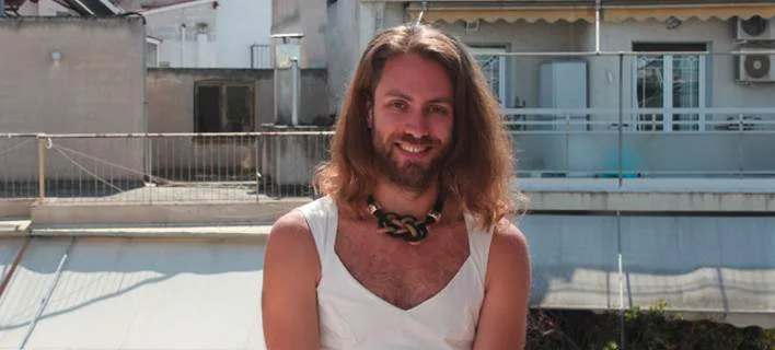 Άτομο με μακριά μαλλιά και λευκό ένδυμα σε εξωτερικό χώρο.