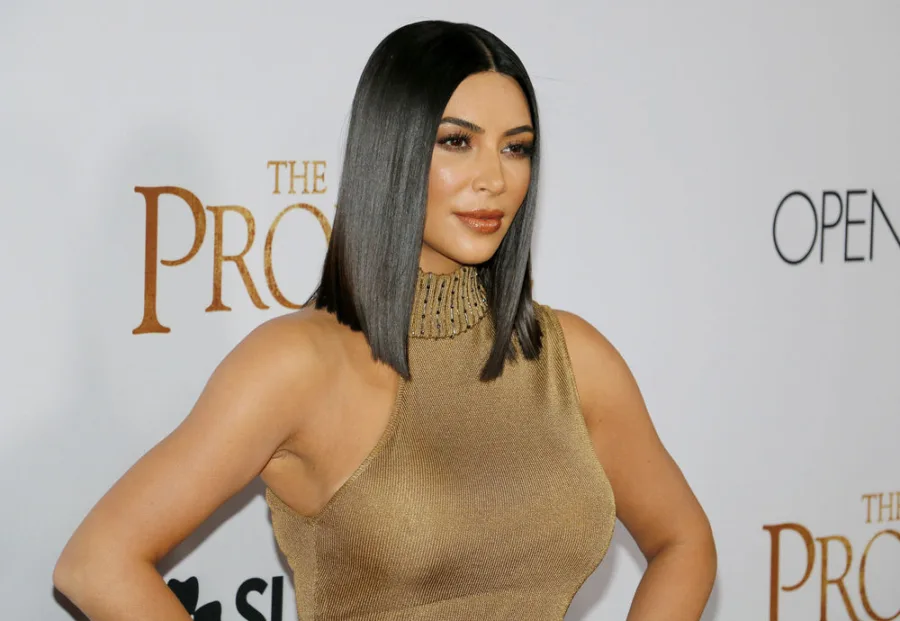 Η Kim Kardashian σε εκδήλωση με χρυσό φόρεμα και καρέ μαλλιά.