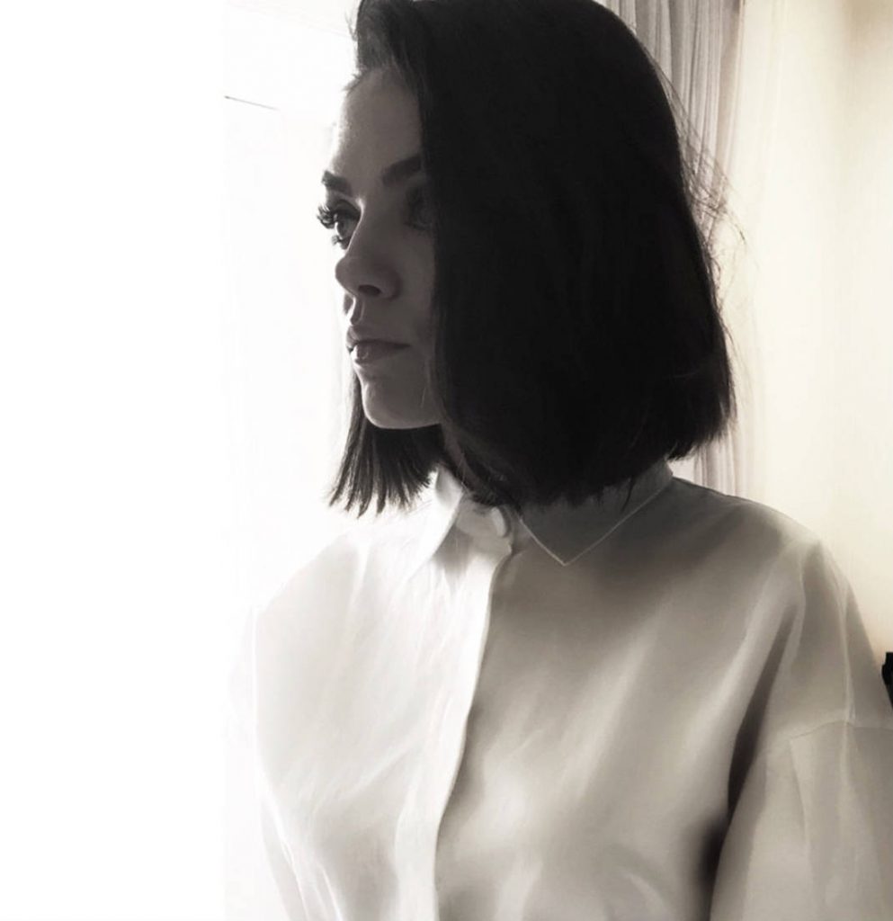 Η Mila Kunis με νέο κοντό καρέ κούρεμα και λευκό πουκάμισο.