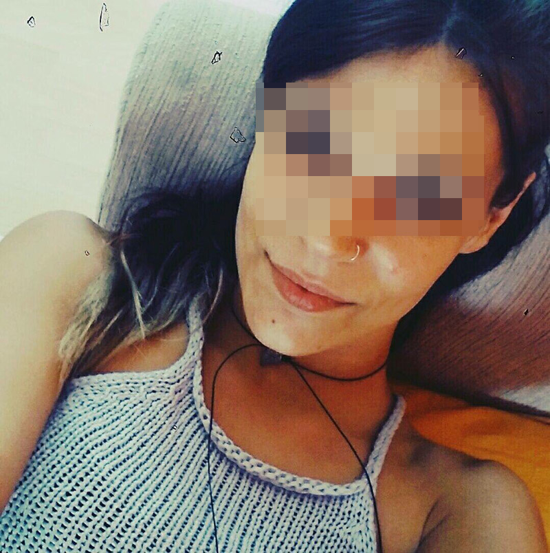 Κοντινό πλάνο νεαρής γυναίκας με σκούρα μαλλιά και σκουλαρίκι στη μύτη.