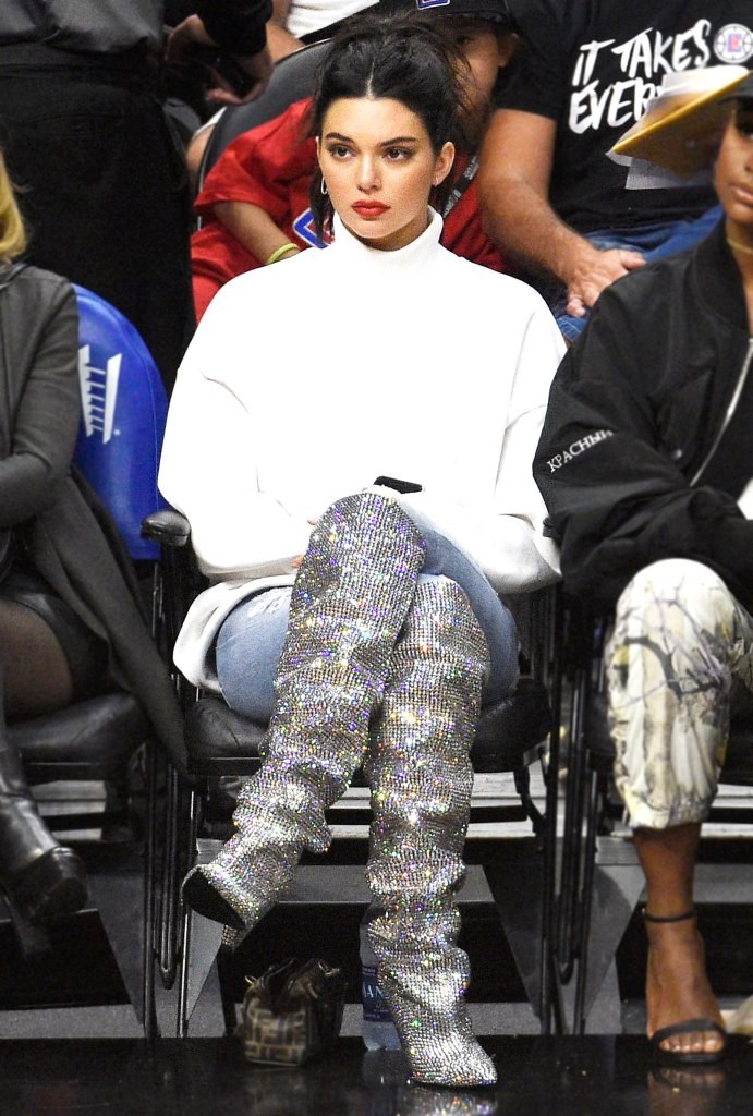 Η Kendall Jenner με λευκό ζιβάγκο και ασημί μπότες με κρύσταλλα σε αγώνα μπάσκετ.