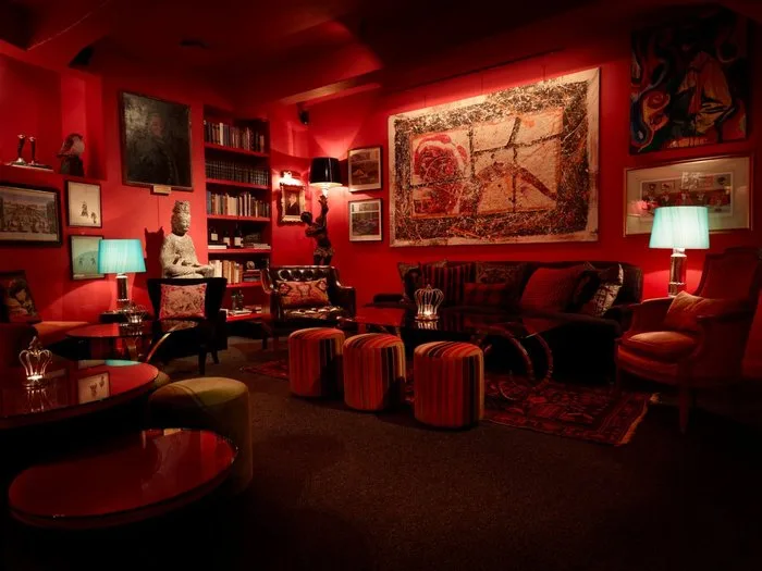 Εσωτερικό ενός από τα ακριβότερα privé club του κόσμου, με κόκκινη διακόσμηση και άνετα καθίσματα.