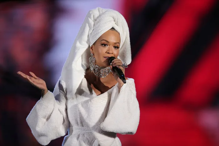 Η Rita Ora στη σκηνή των MTV EMA με λευκό μπουρνούζι και πετσέτα στα μαλλιά.