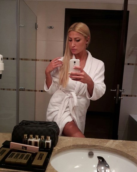 Η Ιωάννα Τούνη με λευκό μπουρνούζι βγάζει selfie στον καθρέφτη του μπάνιου.