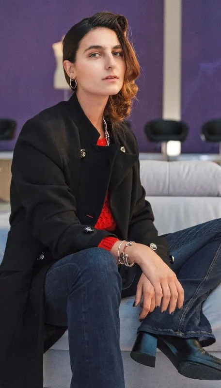 Παίκτρια του My Style Rocks με μαύρο παλτό και τζιν παντελόνι.