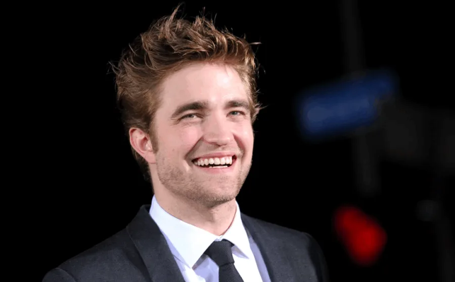 Ο Robert Pattinson χαμογελάει σε επίσημη εμφάνιση.