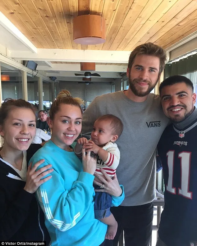 Η Miley Cyrus και ο Liam Hemsworth ποζάρουν με φίλους και ένα μωρό.
