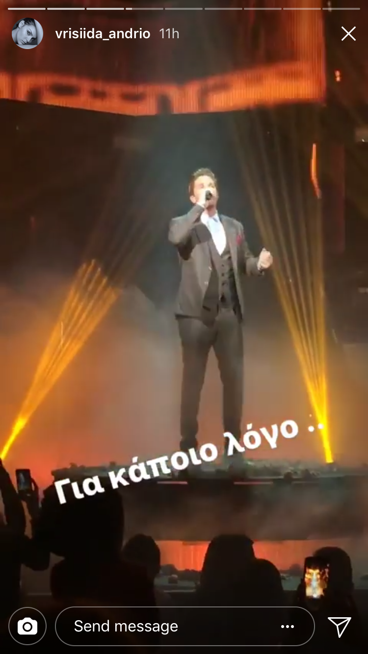 Καλλιτέχνης τραγουδάει σε σκηνή με εφέ φωτισμού.