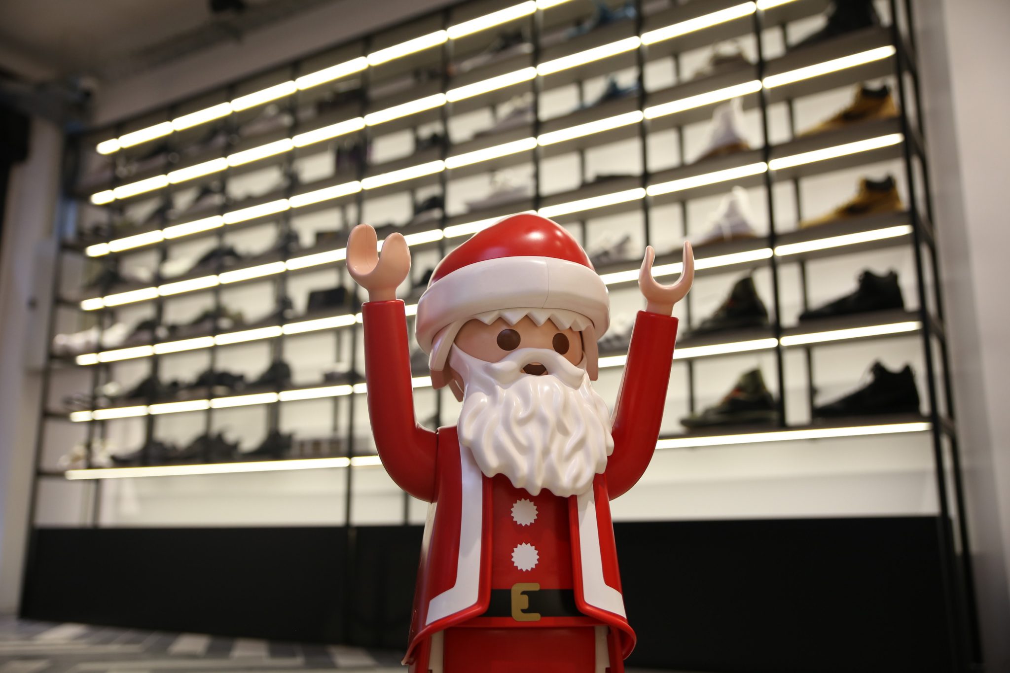 Φιγούρα Playmobil Sneaker Claus μπροστά από ράφια με αθλητικά παπούτσια.