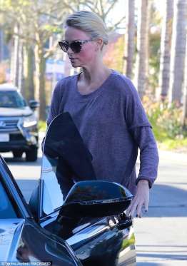 Η Charlize Theron με γυαλιά ηλίου δίπλα σε αυτοκίνητο.