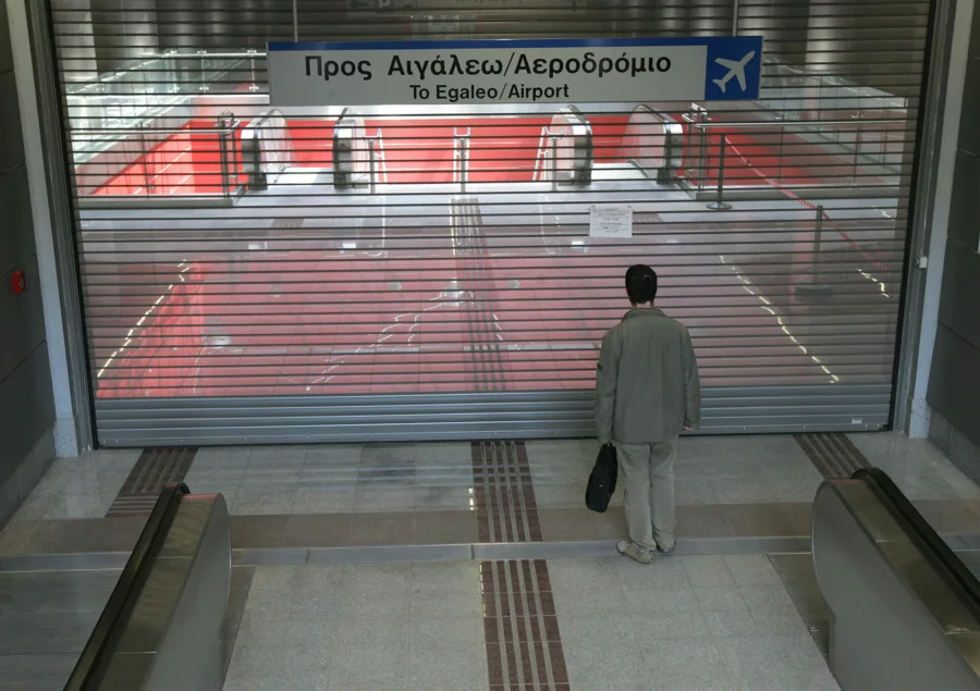 Επιβάτης στο Μετρό της Αθήνας διαβάζει ανακοίνωση για απεργία των εργαζομένων στα μέσα μεταφοράς.