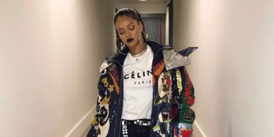 Η Rihanna με πολύχρωμο μπουφάν και λευκό t-shirt σε διάδρομο