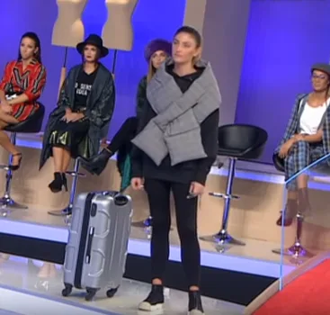 Παίκτρια του My Style Rocks σε πλατό εκπομπής με βαλίτσα.