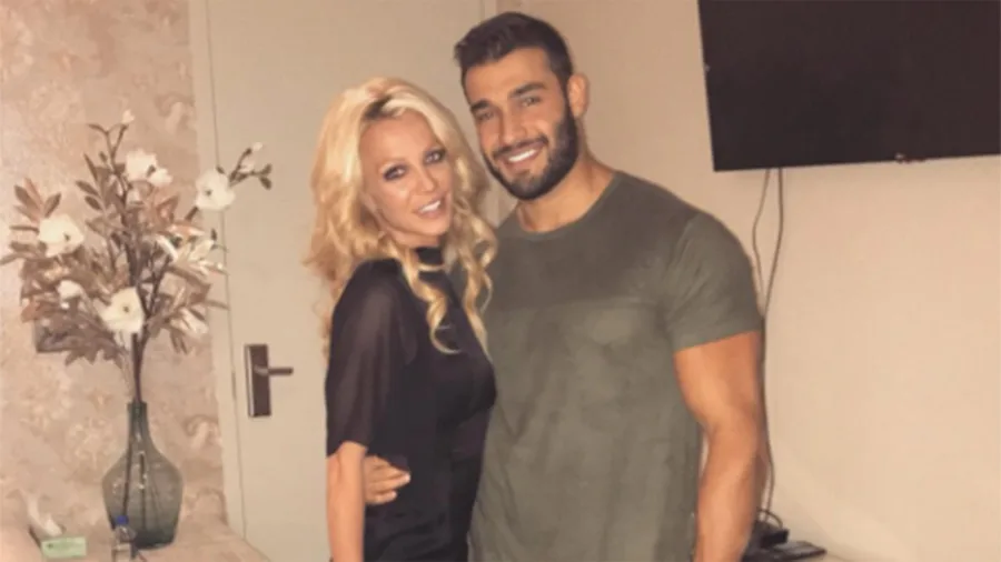 Η Britney Spears και ο Sam Asghari ποζάρουν μαζί σε εσωτερικό χώρο.