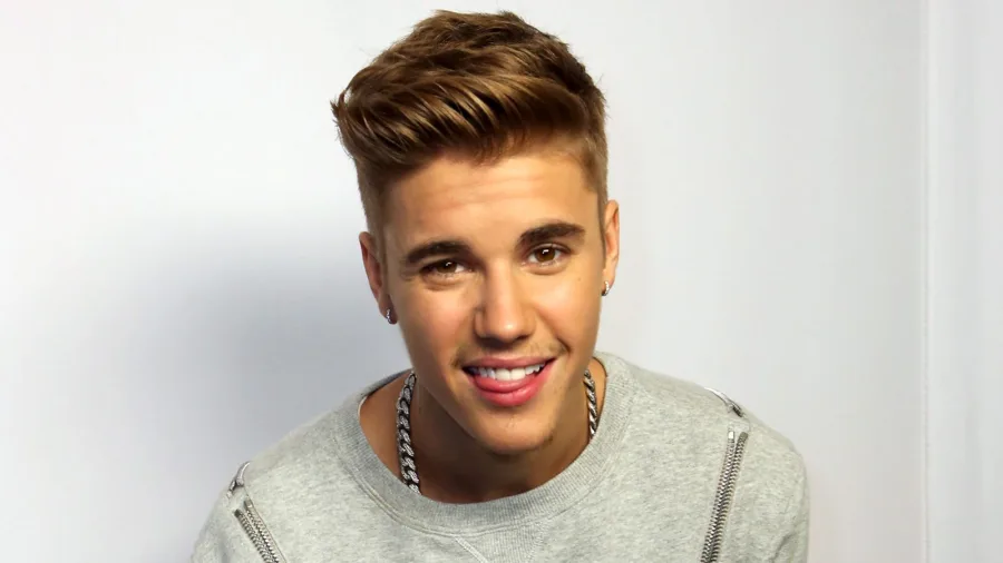 Ο Justin Bieber με ξανθό χτένισμα pompadour και γκρι μπλούζα.