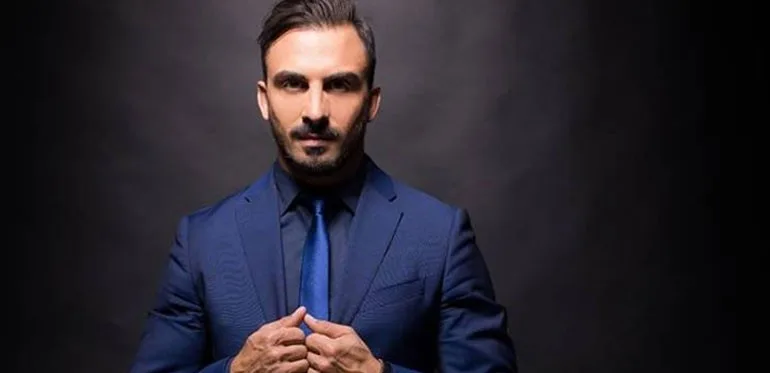 Άνδρας με μπλε κοστούμι και γραβάτα σε σκούρο φόντο
