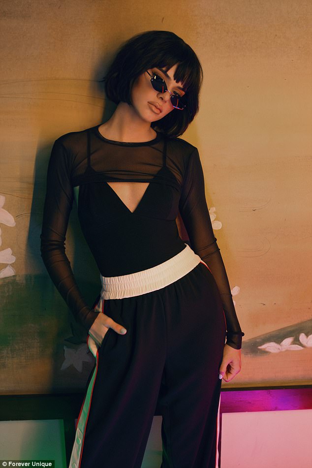 Η Kylie Jenner με μαύρο διάφανο τοπ και αθλητικό παντελόνι.
