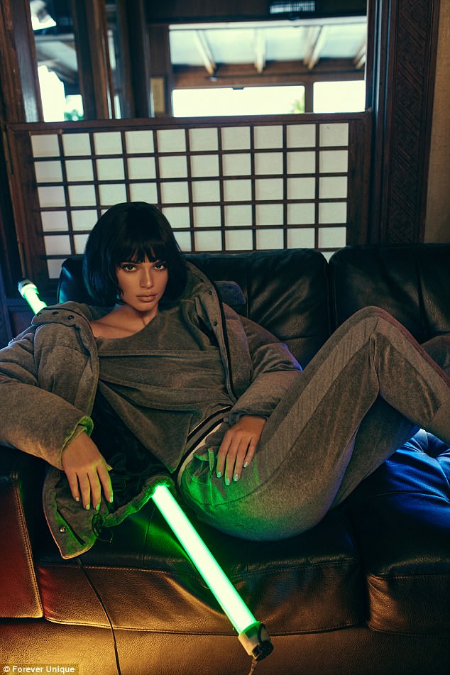 Η Kendall Jenner με κοντό καρέ μαλλί και γκρι αθλητική φόρμα σε καναπέ.