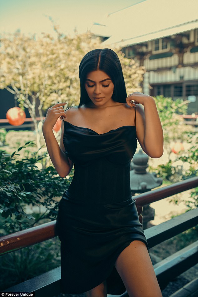 Η Kylie Jenner με μαύρο σατέν φόρεμα σε εξωτερικό χώρο.