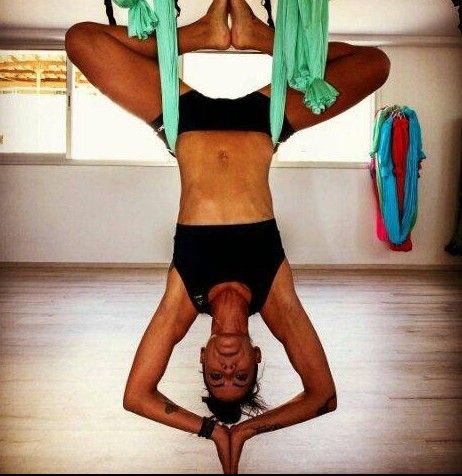 Γυναίκα κάνει aerial yoga σε ανάποδη στάση