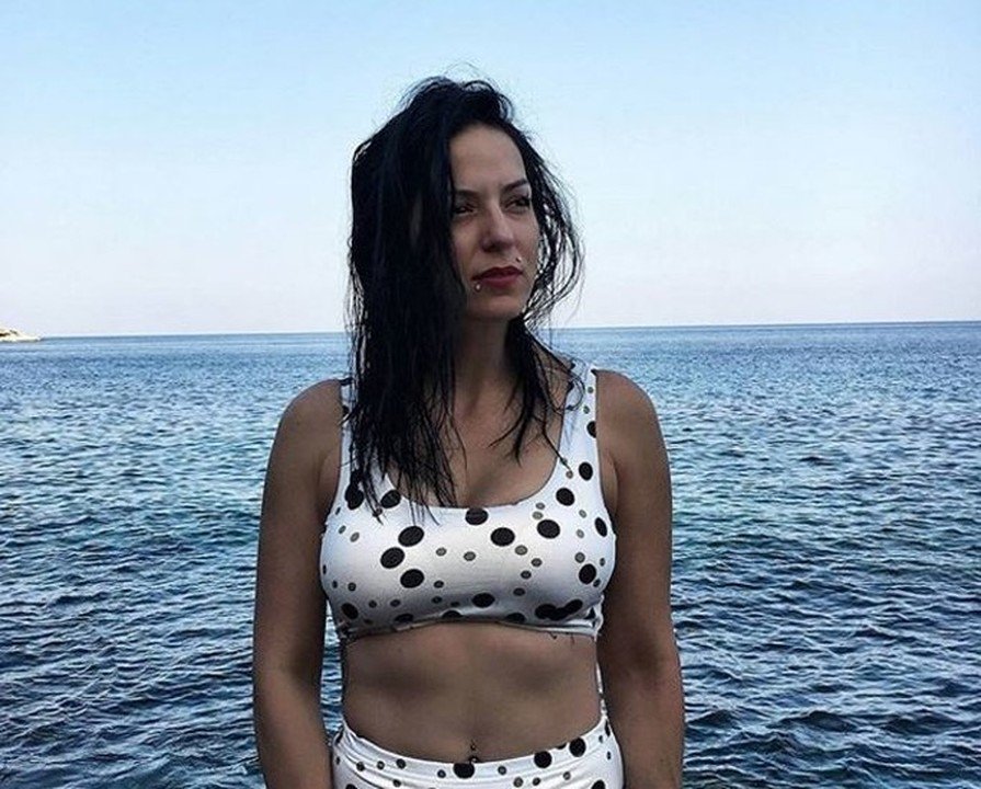 Γυναίκα με πουά μαγιό μπροστά στη θάλασσα