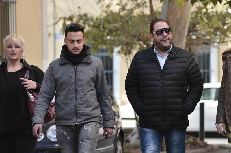 Ο Στέλιος Διονυσίου περπατά στο δρόμο με δύο άλλα άτομα.
