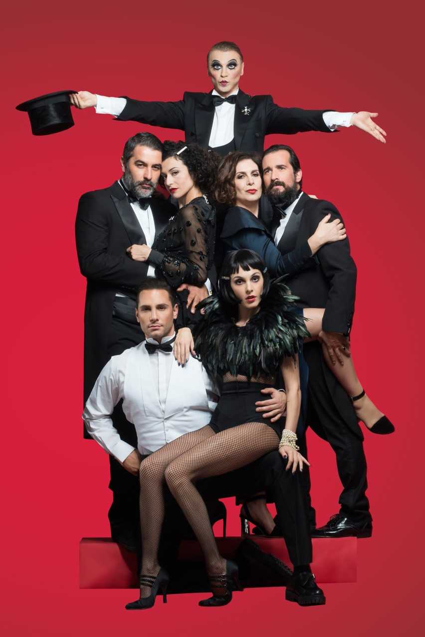 Η Τάμτα με το καστ της θεατρικής παράστασης Cabaret σε κόκκινο φόντο.