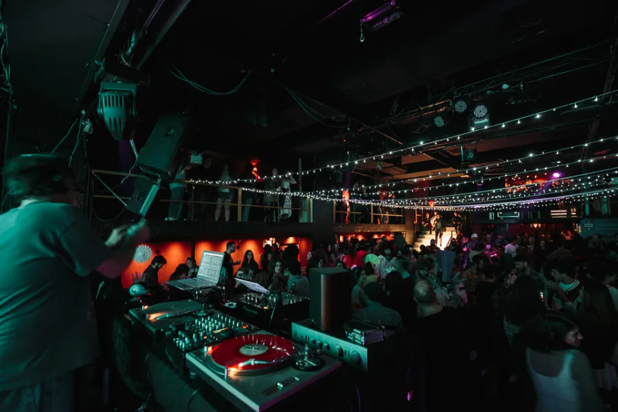 DJ παίζει μουσική σε πάρτι στο κλαμπ TRES με πολύ κόσμο.