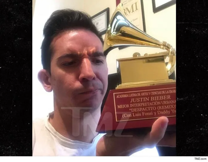Ένας άνδρας κρατάει το βραβείο Latin Grammy του Justin Bieber για το Despacito Remix.