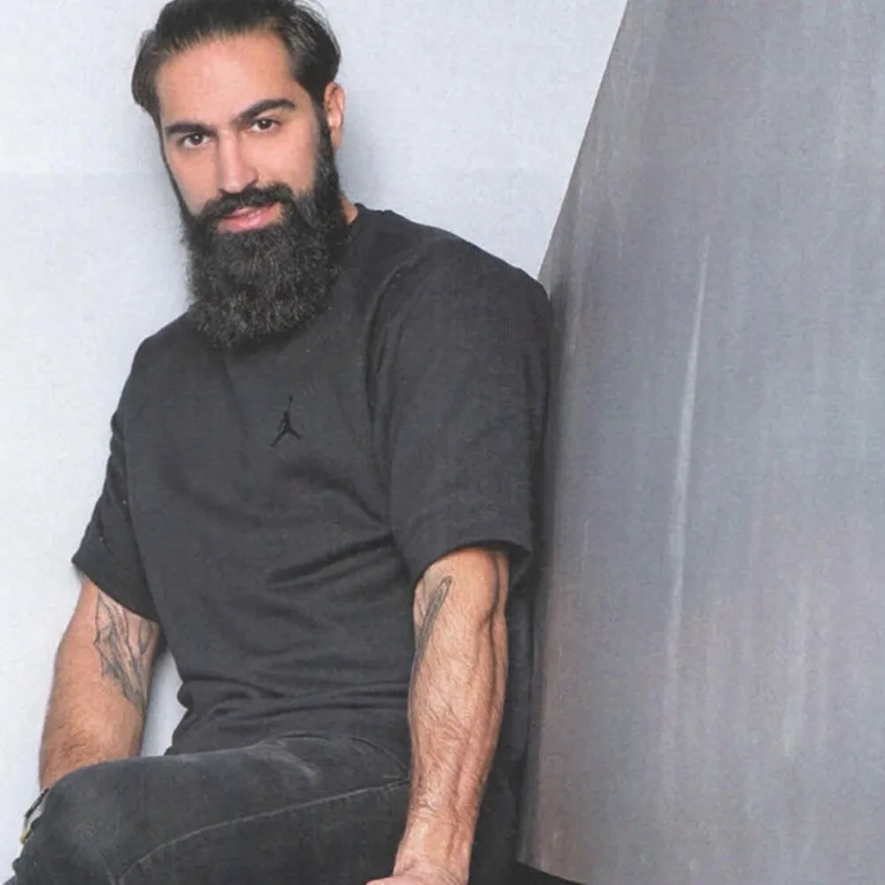 Ο Μιχάλης Σεΐτης με μαύρο t-shirt και πλούσια γενειάδα.
