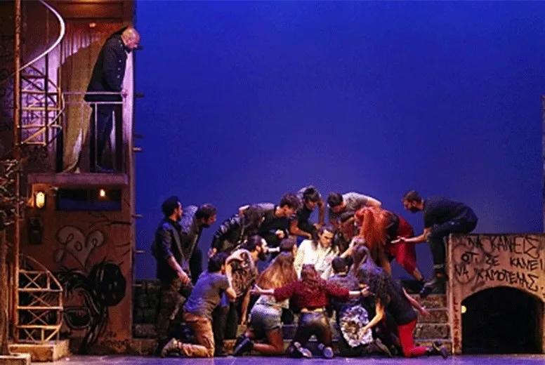 Σκηνή από την παράσταση Jesus Christ Superstar με πολλούς ηθοποιούς στη σκηνή.