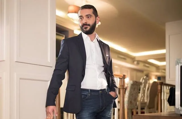 Ο Λεωνίδας Κουτσόπουλος με μπλε σακάκι, λευκό πουκάμισο και τζιν παντελόνι.