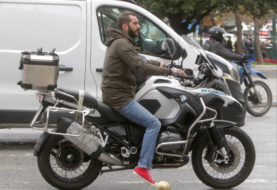 Ο Λεωνίδας Κουτσόπουλος πάνω σε λευκή μηχανή μεγάλου κυβισμού.